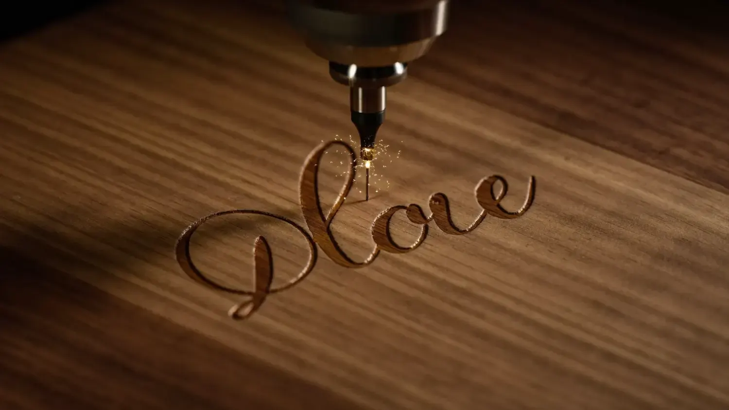 Laser engraver etching an elegant monogram into walnut wood with glowing sparks
